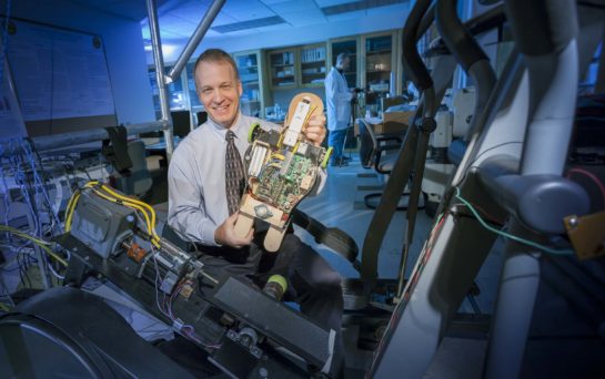 Alumnus Peter Pidcoe holds an early prototype of the Self-initiated Prone Progression Crawler
