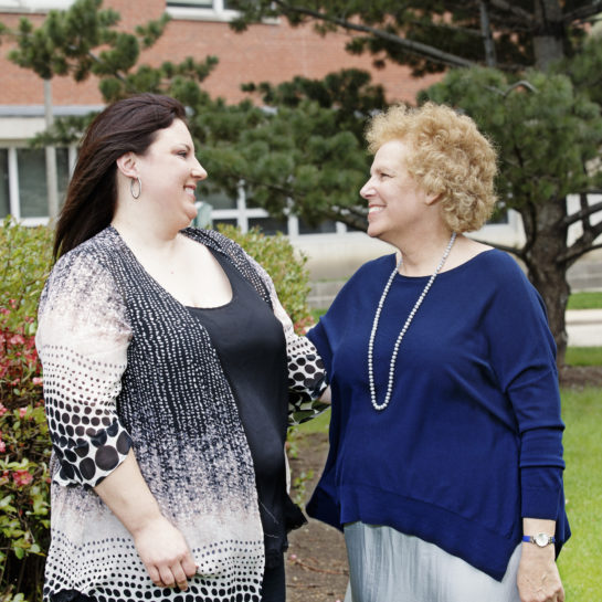 AnnaMaria Baraglia and Carol Gottlieb stand side-by-side outdoors