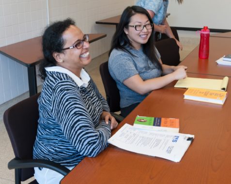Two women smiling at table