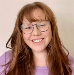 A girl wearing a light purple shirt and glasses