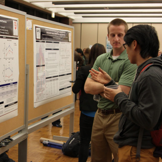 AHS students talking in front of a research poster
