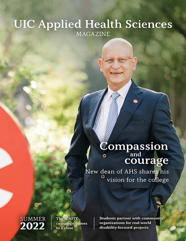 Cover of the summer 2022 issue of AHS magazine depicting dean Carlos J. Crespo standing outside in front of a verdant background with the UIC red circle mark beside him