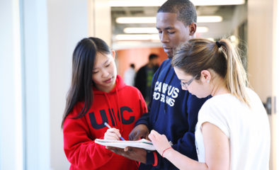 three students studying a piece of paper