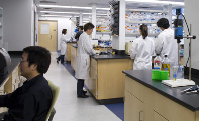 Students in lab coats working in wet lab