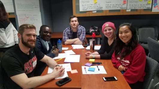 A team of participating students sit around of table 