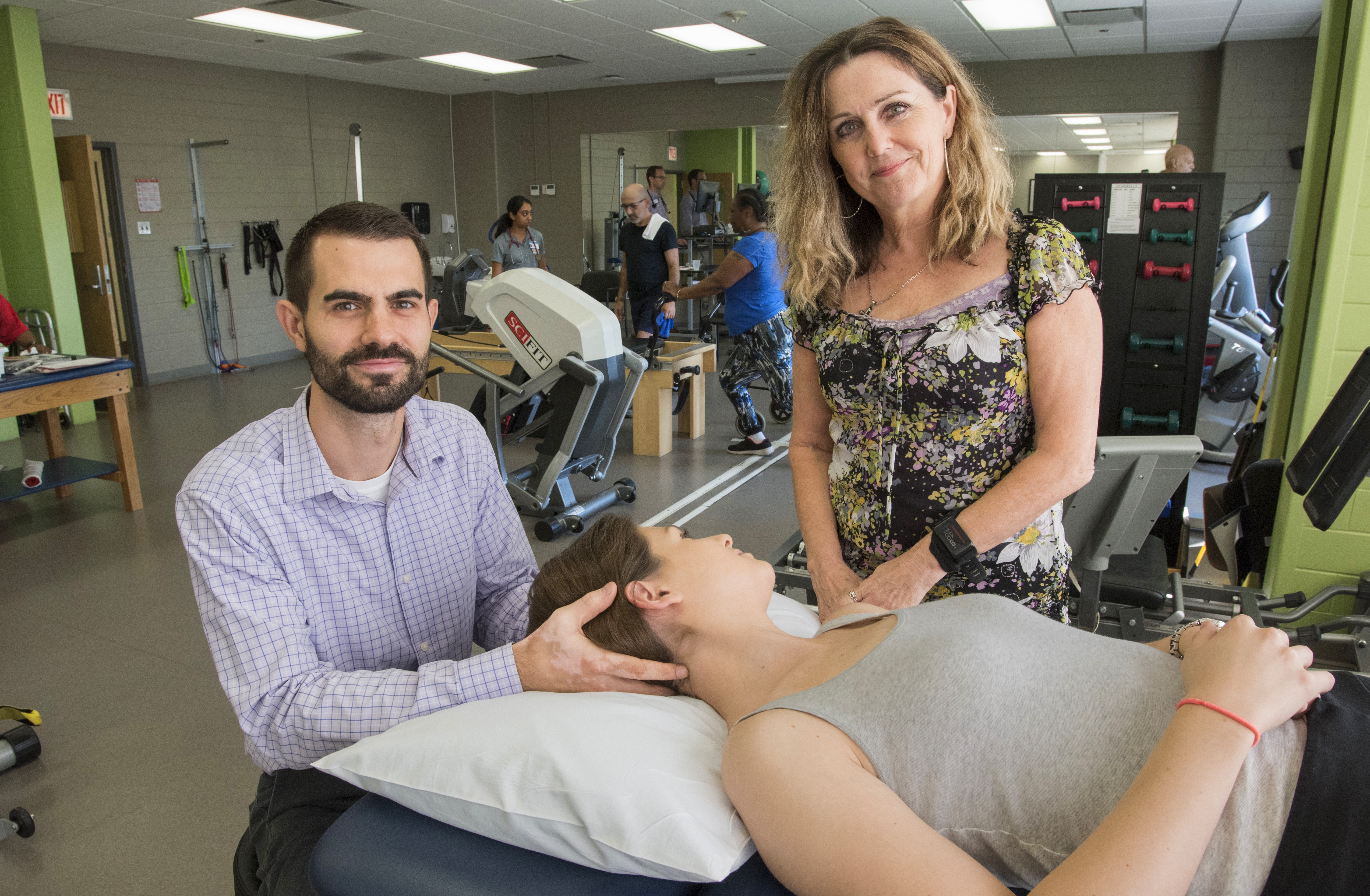 Physical therapists holding head of patient