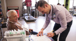 Cemal Ozemek (right) checks the vitals of a cardiac rehabilitation patient (left) while discussing an exercise plan.