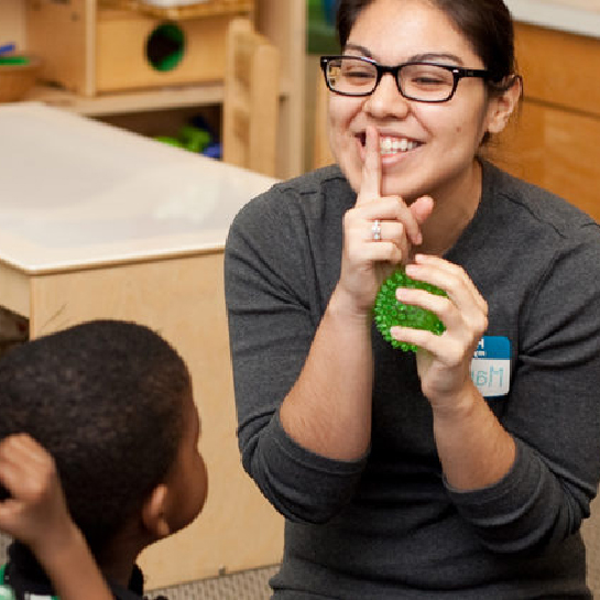 Family Clinic staff member teaching child how to work with tablet computer